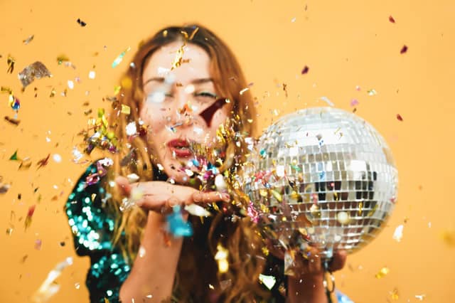 New Years Eve Party Ideas Woamn With Mirror Ball and Confetti