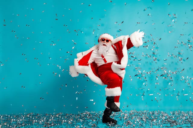 Santa celebrating Christmas with shower of falling confetti from confetti canon